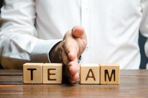 un homme partage avec sa main des cubes avec l'équipe d'inscription. diviser le collectif en deux parties ou dissoudre l'équipe. manque de qualités de leadership et mauvaise qualité de la gestion des affaires. photo