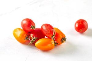 tomates cerises sur marbre blanc, prêtes à cuisiner et à manger photo