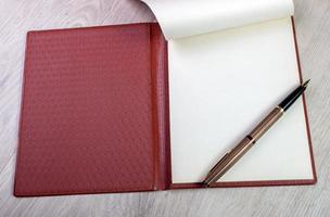 cahier ouvert avec pages blanches et stylo plume doré photo