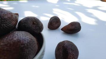 fruits salak dans un bol sur fond blanc, gros plan 01 photo