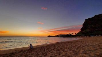 regarder un coucher de soleil hawaïen sur la plage photo