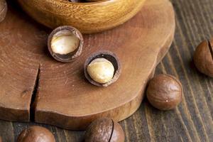 Noix de macadamia non pelées sur une table en bois photo