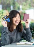 jeune femme assise montrant passeport et carte de crédit photo