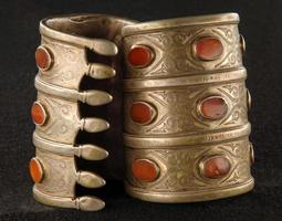les bracelets anciens avec gravure et pierres précieuses isolés sur fond noir photo
