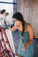 jeune femme artiste peint avec une spatule sur la toile photo