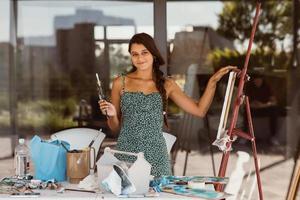 jeune belle artiste féminine avec des outils posant pour la caméra photo