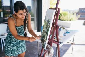 jeune femme artiste peint avec une spatule sur la toile photo