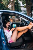 jeune femme assise dans une voiture et tenant un globe photo
