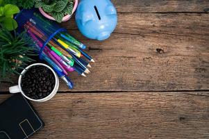 tirelire, plantes, café, cahier, stylos et crayons sur le bureau photo