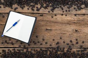 cahier, stylo et grains de café sur le bureau photo