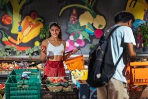 jeune femme ramasser, choisir la tomate en épicerie photo