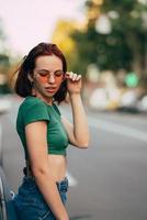 belle jeune femme à la mode dans des verres posant près de la voiture photo