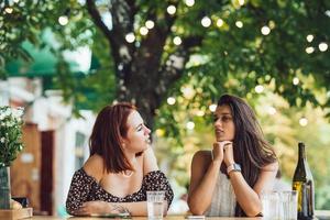 deux belles jeunes femmes copines parler dans un café en plein air photo