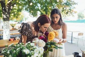 deux jeunes femmes composent un beau bouquet festif. photo