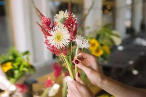 femme fleuriste fait un bouquet de fleurs sauvages fraîches photo
