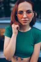 belle jeune femme à la mode dans des verres posant près de la voiture photo