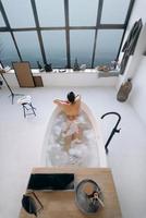 femme détendue prenant un bain, profitant et se relaxant allongée dans la baignoire, vue de dessus photo