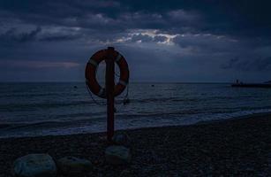 bouée de sauvetage au bord de la mer la nuit photo