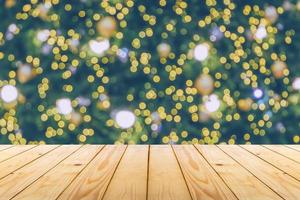 dessus de table en bois vide avec arbre de noël flou avec fond clair bokeh photo