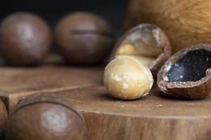 Noix de macadamia non pelées sur une table en bois photo