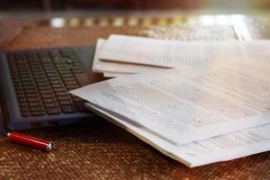 paperasse floue sur un ordinateur portable sur une table au bureau photo