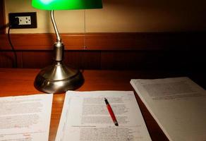 papier de relecture sur une table en bois sous la lumière de la lampe photo