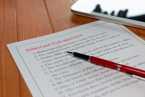 feuille de travail sur l'accord du sujet et du verbe sur une table en bois photo