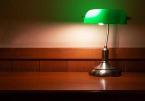 lampe vintage avec abat-jour vert sur un bureau en bois photo