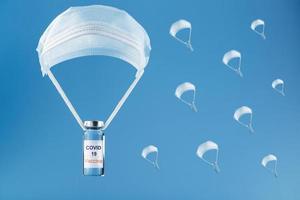 des ampoules contenant un vaccin contre l'infection à coronavirus covid-19 ont été larguées en parachute à partir d'un masque de protection sur fond bleu. photo