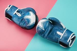 gants de boxe bleus sur fond rose et bleu en diagonale. photo