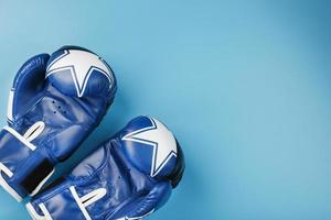 une paire de gants de boxe en cuir sur fond bleu, espace libre. photo