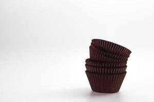 étuis à cupcakes marron sur fond blanc. matériel de cuisson. photo