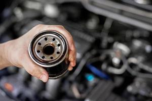 gros plan du filtre à huile usagé de la voiture à moteur dans la main un concept de service d'homme d'huile pendant la période de contrôle photo