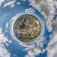 petite planète dans le ciel avec des nuages surplombant la vieille ville, le développement urbain, les bâtiments historiques et les carrefours. transformation du panorama sphérique 360 en vue aérienne abstraite. photo