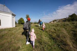 activité le jour d'automne ensoleillé, les enfants explorent la nature. les enfants portent un sac à dos de randonnée avec leur mère. photo