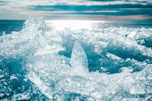 la photo en gros plan d'une glace concassée brillante sur un fond de coucher de soleil sur la mer