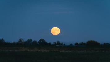 la pleine lune se lève à hansweert zeeland, pays-bas. photo