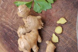 racine de gingembre coupée en tranches sur fond de bois photo