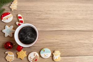 joyeux noël avec des biscuits faits maison et une tasse de café sur fond de table en bois. concept de veille de noël, fête, vacances et bonne année photo