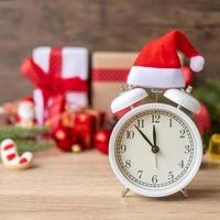 joyeux noël avec réveil vintage et décoration de noël sur table en bois. concept de fête, de vacances et de boxe photo