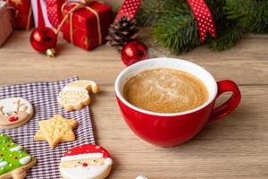 joyeux noël avec des biscuits faits maison et une tasse de café sur fond de table en bois. concept de veille de noël, fête, vacances et bonne année photo