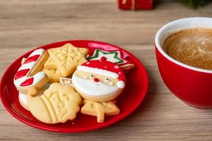 joyeux noël avec des biscuits faits maison et une tasse de café sur fond de table en bois. concept de veille de noël, fête, vacances et bonne année photo