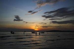 silhouette de navire et bateau à longue queue sur la mer ou l'océan avec ciel bleu et nuage au coucher du soleil, au lever du soleil ou au crépuscule à krabi, en thaïlande. beauté dans la nature avec concept de vague et de transport photo