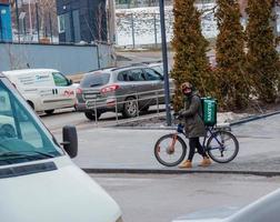 dnepropetrovsk, ukraine - 02.07.2022 un courrier de service de livraison avec un sac thermique sur un vélo fait le tour de la ville. livraison de repas à domicile. photo