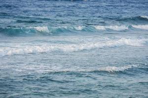 hautes vagues sur une plage avec de l'eau de mer bleue photo