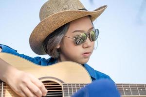 gros plan femme porter un chapeau et jouer de la guitare photo