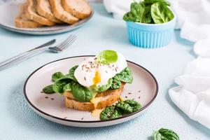 bruschetta appétissante avec œuf poché et épinards sur une assiette. régime céto. photo