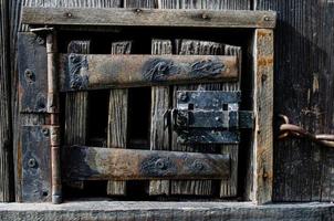 Serrure sur une vieille porte en bois avec inserts rouillés photo