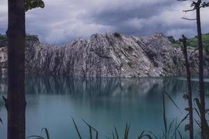 les montagnes calcaires après l'explosion de la concession pendant la saison des pluies forment un grand et bel étang. photo