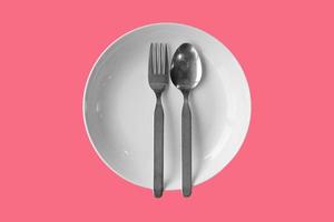 Cuillère fourchette assiette vide sur un fond de couleur avec un tracé de détourage photo